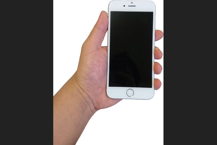 白いスマートフォンを握っている